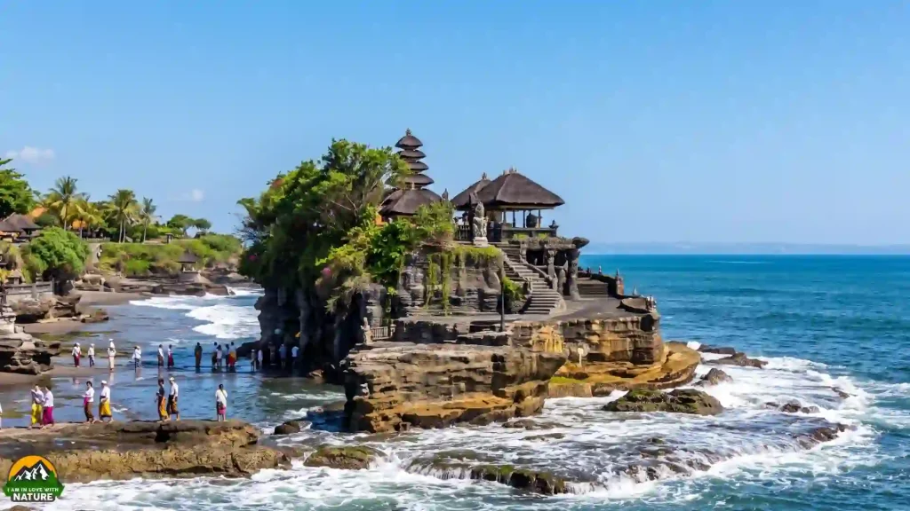 Ultimate Bali Travel Guide 10 Tanah Lot Hindu sea temple on a rocky offshore outcrop with waves and visitors in sarongs, Tabanan, Bali